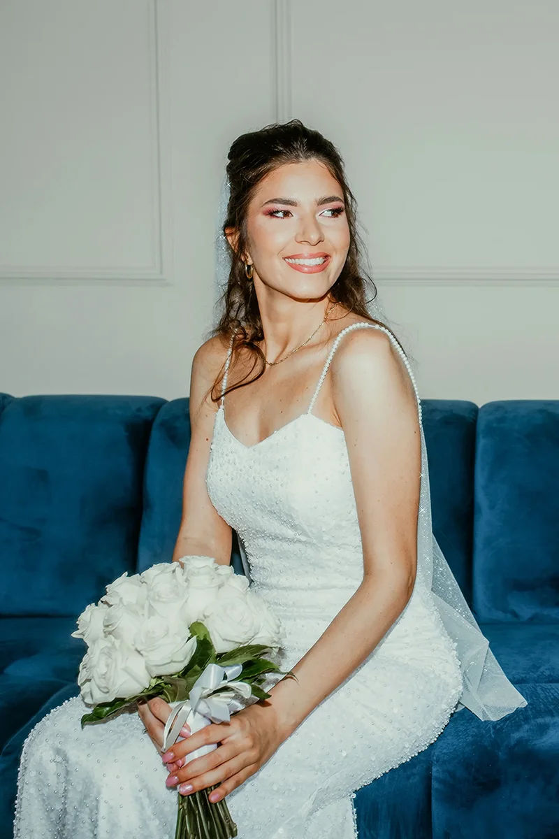 Mlada na plavom kauču sa buketom – fotograf Niš